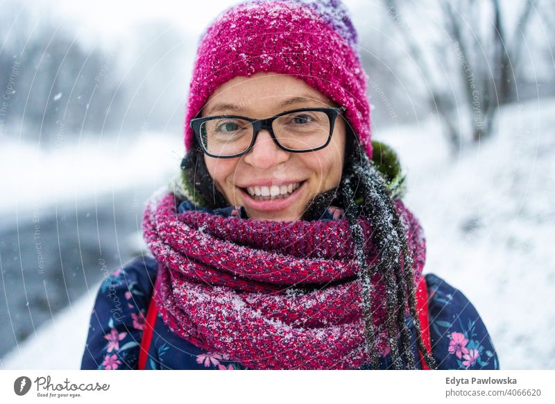 Porträt einer Frau mit Wollmütze und Schal im Winter Brille außerhalb natürlich Gesundheit Fausthandschuh Bäume Handschuhe Schneeflocke Weihnachten Schönheit
