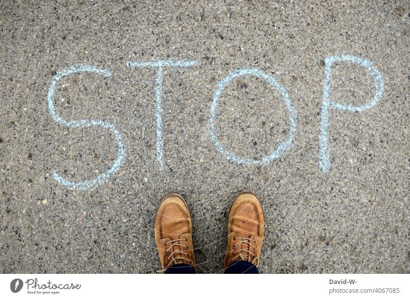 Stop - Hinweis - Kreide auf dem Boden Wort anhalten Achtung Mensch Stillstand stopp Einschnitt verbot