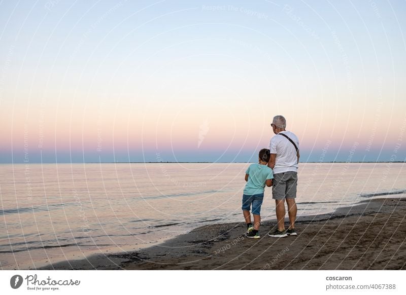 Großvater und sein Enkel Blick auf den Ozean bei Sonnenuntergang Strand Junge Kind Kindheit Küste Papa Abend Familie Vater Freiheit Spaß Generation golden