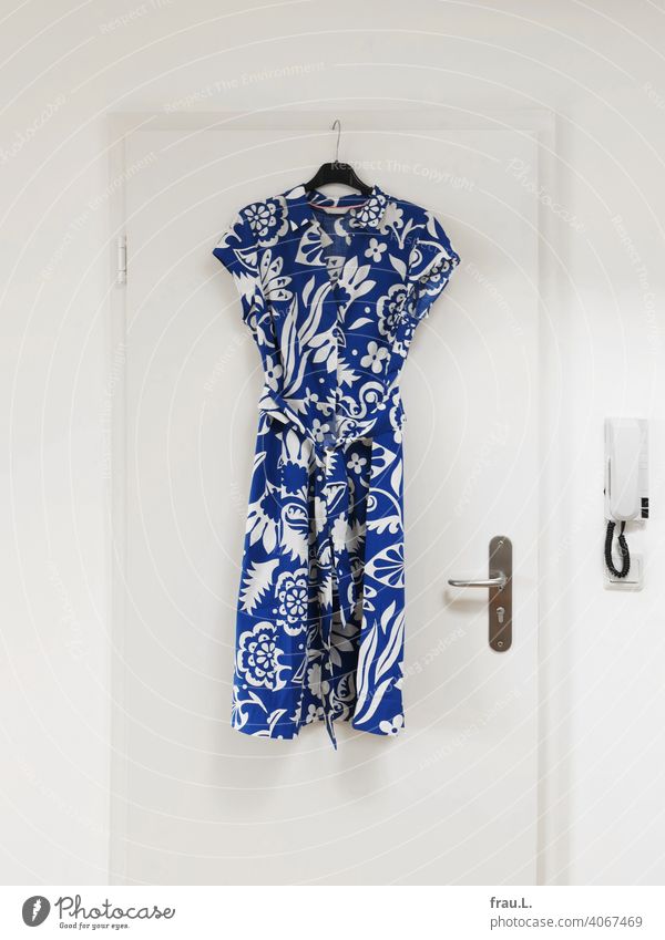 Ein Sommerkleid hängt an der Tür Mode Kleiderbügel Türklincke bunt Gegensprechanlage Muster blau Bekleidung Stoff hängen
