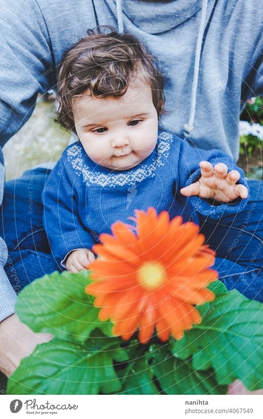 Kleines Baby, das zum ersten Mal eine riesige Blume entdeckt entdecken Frühling Fröhlichkeit Familie Familienzeit Papa Vater Mädchen Kind Kleinkind 9 Monat