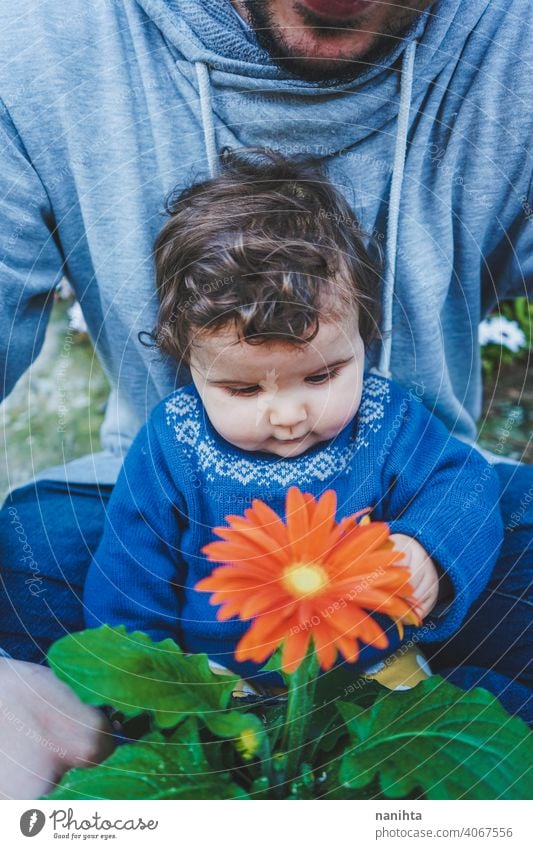 Kleines Baby, das zum ersten Mal eine riesige Blume entdeckt entdecken Frühling Fröhlichkeit Familie Familienzeit Papa Vater Mädchen Kind Kleinkind 9 Monat
