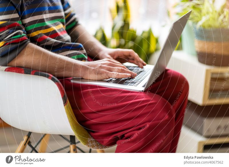 Ausgeschnittene Aufnahme eines nicht erkennbaren Mannes, der einen Laptop zu Hause benutzt online Onlinebanking Online-Lernen Online-Shopping Büro heimwärts