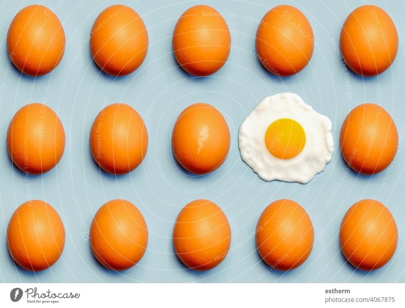 Draufsicht auf ein kreatives Muster aus braunen Eiern und einem Spiegelei Hühnereier Ostereier Hähnchen frisch Eigelb essen Container Korb Landwirtschaft Lager