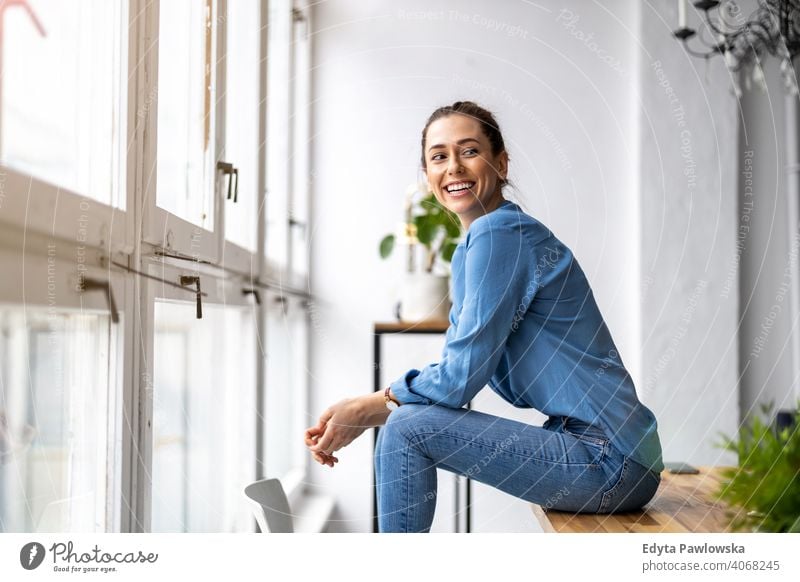 Porträt einer lächelnden kreativen Frau in einem modernen Loft-Raum Jahrtausende Schüler Hipster im Innenbereich Fenster natürlich Mädchen Erwachsener attraktiv