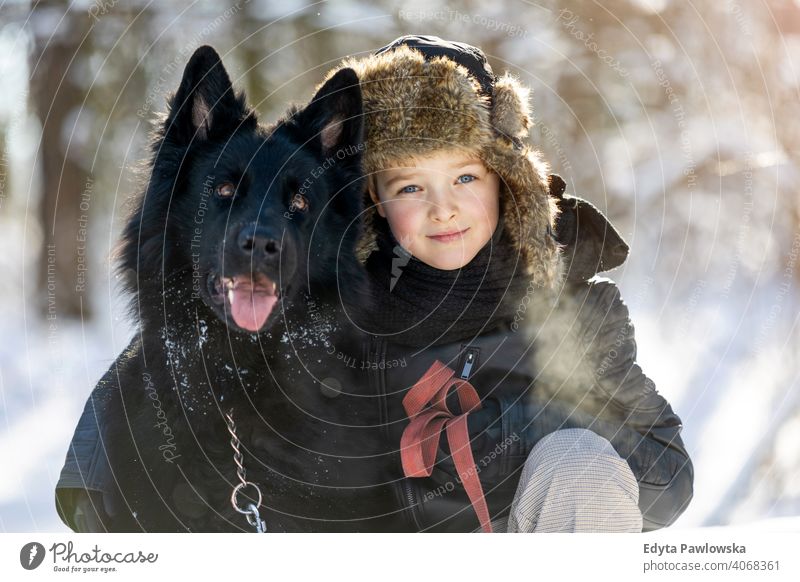 Kleiner Junge genießt den Winter mit seinem Hund schwarz Russisch Aktivität aktiv Abenteuer Tag männlich Begleiter Pflege im Freien Wald Schönheit Frost Natur