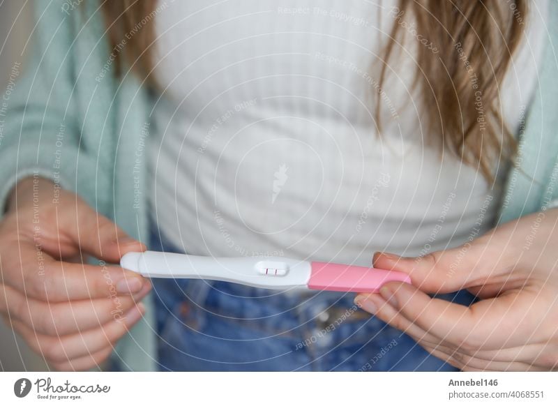 Glückliche junge Frau hält einen positiven Schwangerschaftstest Nahaufnahme hellen Farben modernen stilvollen Design schwanger Prüfung Ergebnis Beteiligung