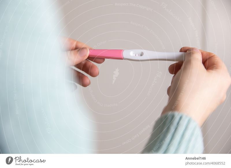 Glückliche junge Frau hält einen positiven Schwangerschaftstest Nahaufnahme hellen Farben modernen stilvollen Design schwanger Prüfung Ergebnis Beteiligung