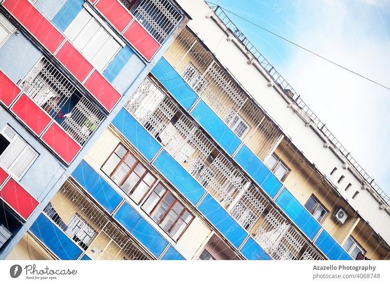 Gekipptes Bild eines Gebäudes mit bunten Balkonen. Winkel Winkelperspektive Winkelansicht Appartement Architektur Klotz blau Großstadt Stadtbild farbenfroh
