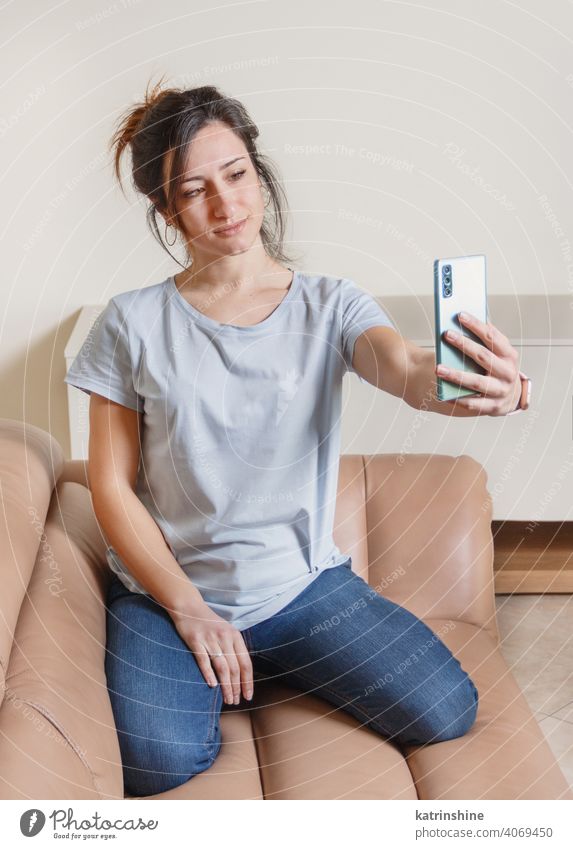 Junge Frauen nehmen Selfie mit Handy jung anhaben Attrappe T-Shirt im Innenbereich allein Telefon Smartphone Lifestyle Jeanshose Brille Rundhals lässig Person