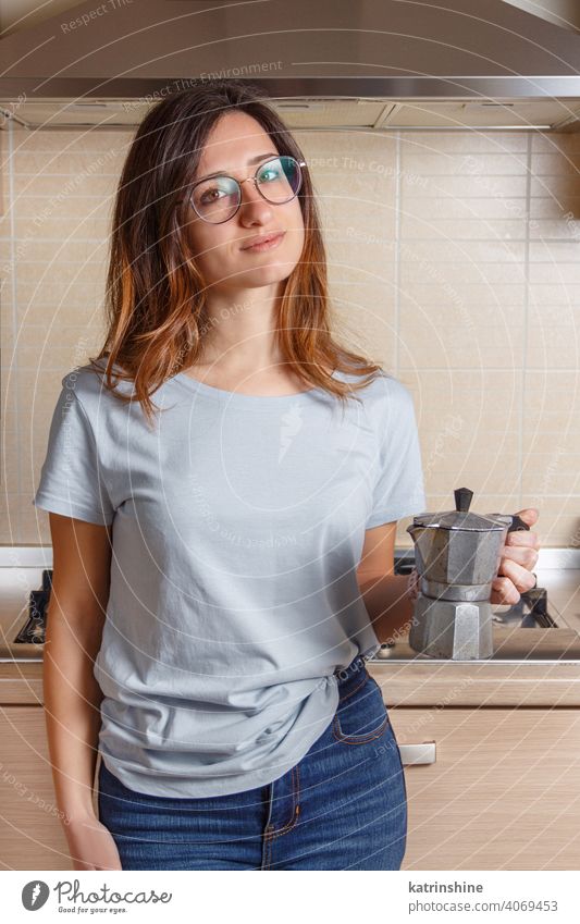 Junge Frauen bleibt in der Küche zu Hause mit Kaffee Moka Pot jung blau T-Shirt heimwärts Mokka Topf Moka-Topf anhaben Attrappe Lifestyle Jeanshose Brille