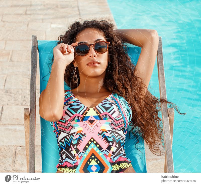 Junge Frau im einteiligen Badeanzug entspannt in der Nähe eines Schwimmbads rot tropisch Pool Wasser Sommer jung Kaukasier Mode allein Garten im Freien exotisch