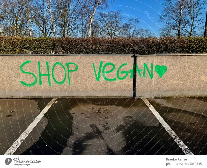SHOP VEGAN - in grüner Schrift auf eine Mauer geschrieben auf einem Parkplatz vegan Vegane Ernährung veganismus vegan einkaufen shoppen pflanzlich Einkauf