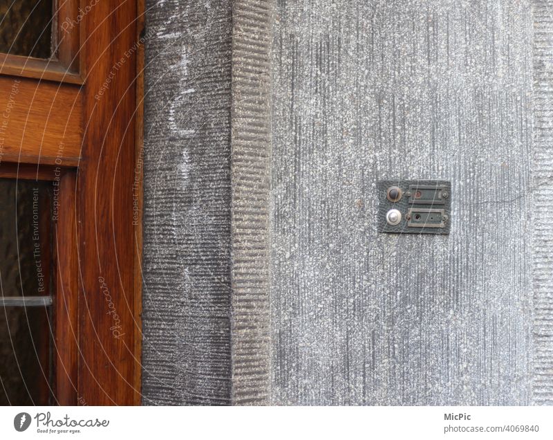 Leerstand  - leeres Klingelschild an grauer Hauswand mit brauner Holztür leerstehend namenlos Hauseingang alt Außenaufnahme Gebäude Wand Menschenleer trist