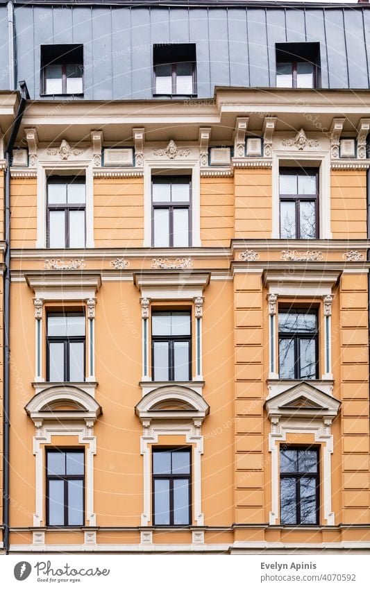 Orangefarbene Backstein-Jugendstil-Gebäudefassade mit neun cremefarbenen Fenstern in Riga, Lettland, Europa baltisch Architektur Fassade Haus Großstadt