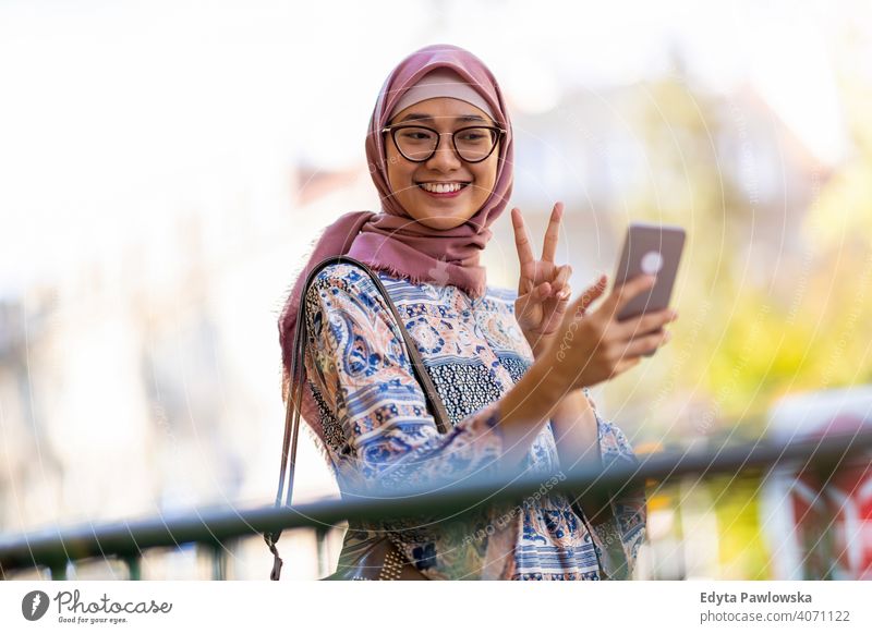 Junge Frau trägt einen Hijab und macht ein Selfie Kopftuch muslimisch Islam arabisch Sommer Mädchen Menschen junger Erwachsener Lifestyle aktiv im Freien
