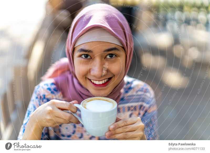 Glückliche junge muslimische Frau trinkt Kaffee Hijab Kopftuch Islam arabisch Sommer Mädchen Menschen junger Erwachsener Lifestyle aktiv im Freien tausendjährig