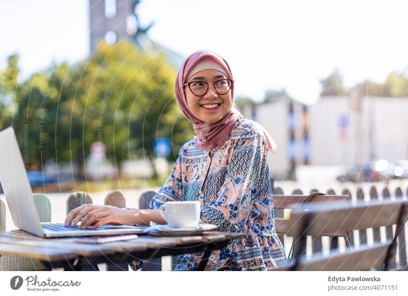 Junge muslimische Frau, die einen Laptop in einem Straßencafé benutzt Hijab Kopftuch Islam arabisch Sommer Mädchen Menschen junger Erwachsener Lifestyle aktiv