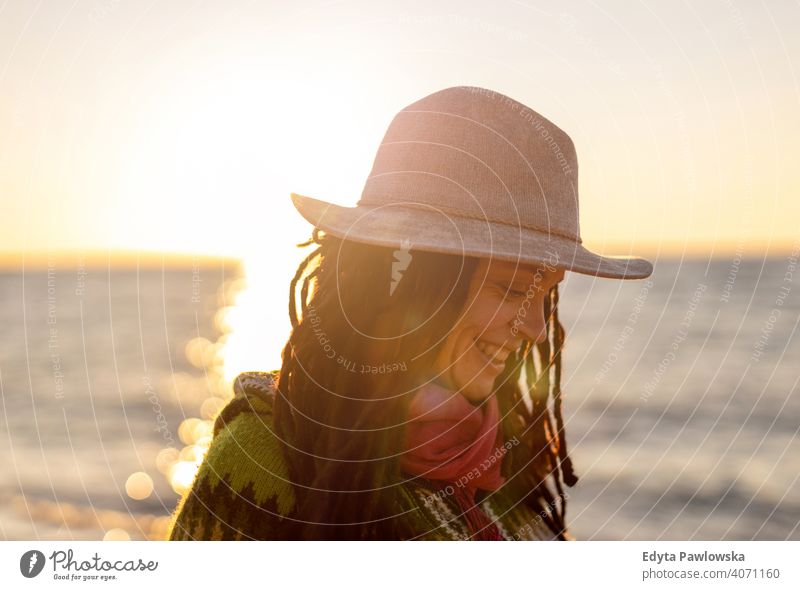 Junge Frau mit einem Hut am Strand bei Sonnenuntergang reisen Tourist Tourismus Urlaub Backpacker schön attraktiv jung Erwachsener Menschen im Freien lässig