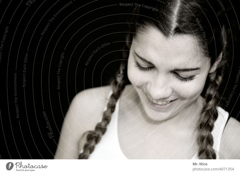 junge Frau mit geflochtenen Zöpfen blickt nach unten Portrait Porträt Kopf Gesicht Schulter feminin ästhetisch Sehnsucht natürlich Gefühle Coolness schön