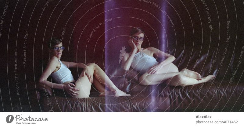 Analoges Doppelportrait einer jungen Frau auf einer braunen Ledercouch durch Transportfehler in der Canon A-1 Kamera mit Lightleaks junge Frau schlank Top