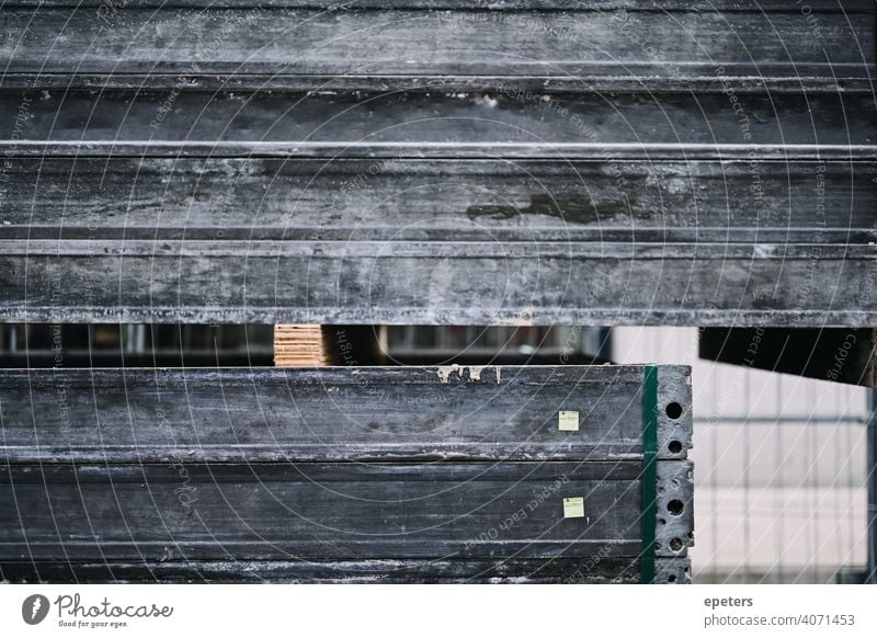 Ein Stapel von Metallregalen auf einer Baustelle Aluminium Hintergrund Bar Kohlenstoff Nahaufnahme Konstruktion Textfreiraum dreckig Maschinenbau Fabrik grau
