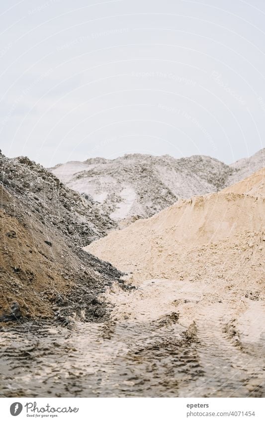 Sandhaufen auf einer Baustelle an einem bewölkten Tag Hintergrund Konstruktion Textfreiraum Detailaufnahme Geologie Kies Streusand Haufen industriell