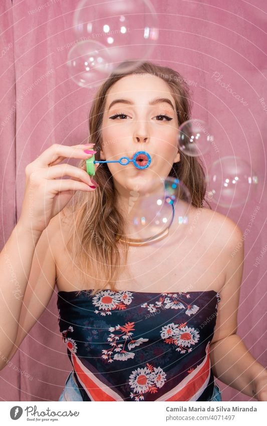 Glückliche Frau macht Seifenblasen mit rosa Hintergrund. bezaubernd schön Geburtstag Blasen Feier heiter Emotion Gefühle Gesicht Mode lustig Mädchen Glamour
