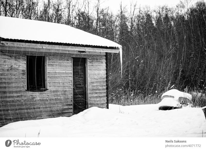 alte hölzerne Fischerhütte mit großem Eiszapfen, Boot in der Nähe. Winterlandschaft Verlassen gealtert Ackerbau Architektur baltisch Scheune blau Gebäude Kabine