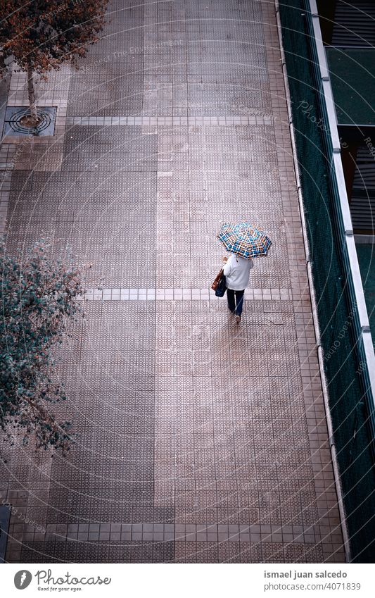 Frau auf der Straße mit einem Regenschirm in regnerischen Tagen Menschen Person regnet Regentag Wasser menschlich Fußgänger Großstadt urban Bilbao Spanien