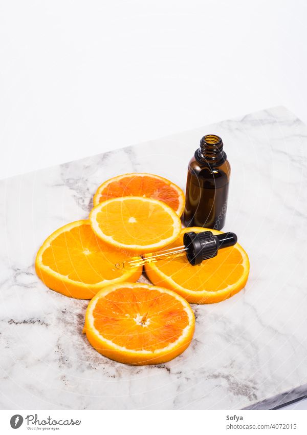 Vitamin C Serum Flasche mit Tropfer auf weißem Marmor Hintergrund orange notwendig Erdöl Schönheit Aromatherapie Murmel Glas Haut Pflege Scheibe hell dunkel