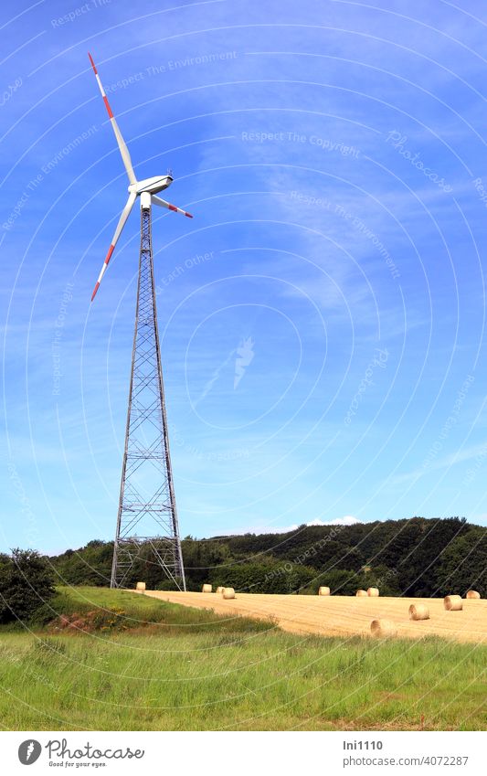 Windkraftanlage steht auf einem Feld mit Strohballen Windrad Erneuerbare Energie Umwelt CO2 Herbst Erntezeit Blauer Himmel Metall Flügel Motor