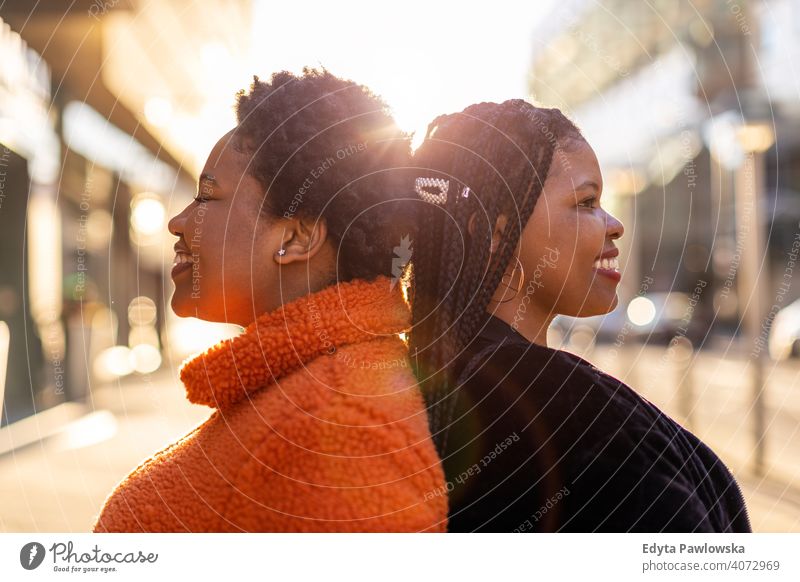 Zwei schöne afroamerikanische Frauen stehen Rücken an Rücken in der Stadt Vielfalt unterschiedliche Menschen Liebe im Freien Tag Positivität selbstbewusst