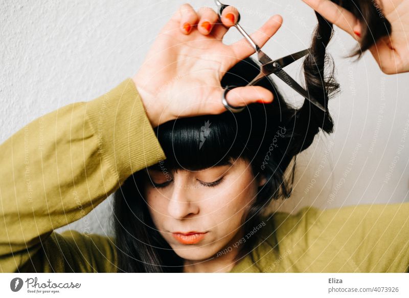 Frau schneidet sich selber die Haare Haare schneiden Haarschnitt Lockdown selber machen DIY Friseurin nachschneiden Haare & Frisuren Schere dunkelhaarig zuhause
