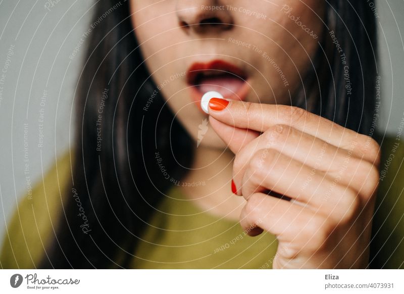 Frau nimmt eine Tablette Schmerztablette Medizin Medikament Krankheit Behandlung Kopfschmerzen Migräne Schmerzmittel Kopfschmerztablette