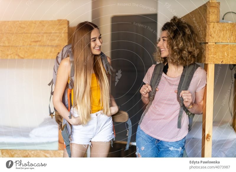 Junge Frauen mit Rucksäcken bei der Ankunft in einer Jugendherberge airbnb Miete reisen Tourist Herberge Gästehaus Ferien Reise flach Rucksack Backpacker