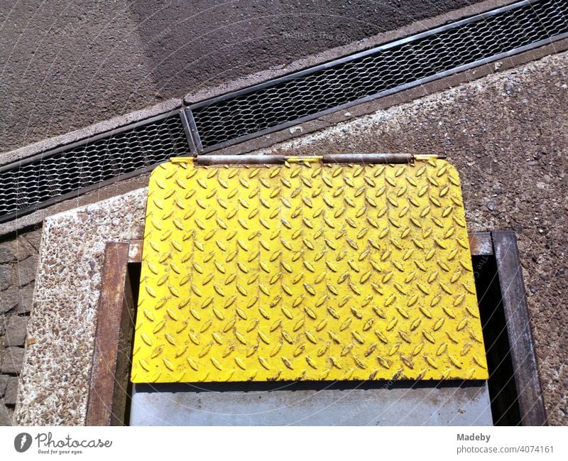Gelb lackiertes Riffelblech an einem Prüfstand vor einer alten Autowerkstatt bei Sonnenschein in Wettenberg Krofdorf-Gleiberg bei Gießen in Hessen Knallgelb