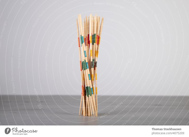 Mikado-Spielstöcke, auf ein Holzbrett gefallen, Bewegungsunschärfe Gleichgewicht Holzplatte Herausforderung chaotisch Kinderspiel farbenfroh Konzentration