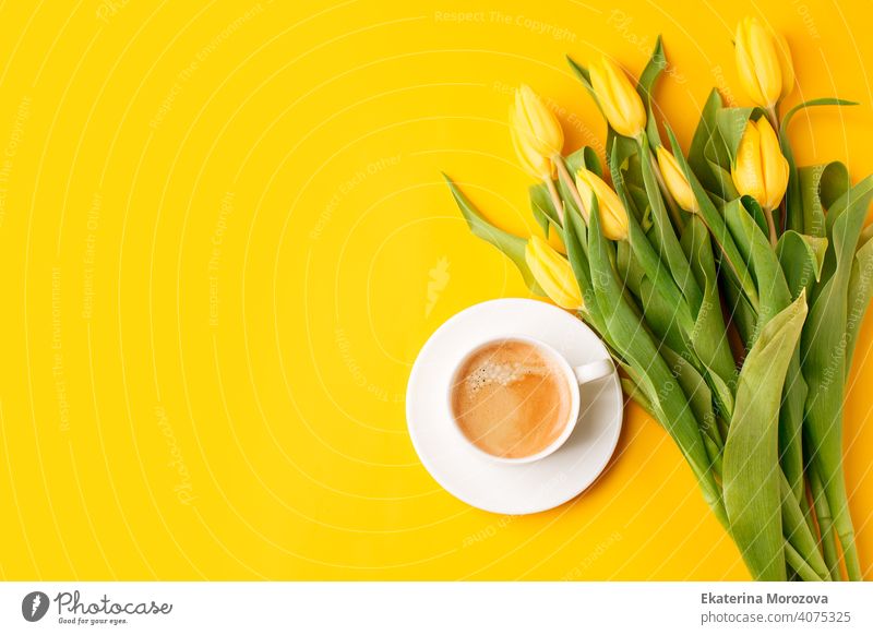 Schöne Frühling Frühstück auf Mütter oder Womans International Day 8 März. Blumenstrauß von gelben Tulpen und Kaffeetasse auf leuchtend gelben Tisch Draufsicht. Flat Lay, stilvolle Banner für Website, saisonale Flyer