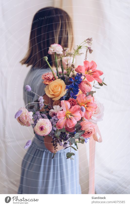 Junge Frau in einem hellblauen Kleid mit einem Blumenstrauß in der Hand. Romantisches Konzept. Mädchen weiches Licht schön altehrwürdig Hochzeit weiß jung