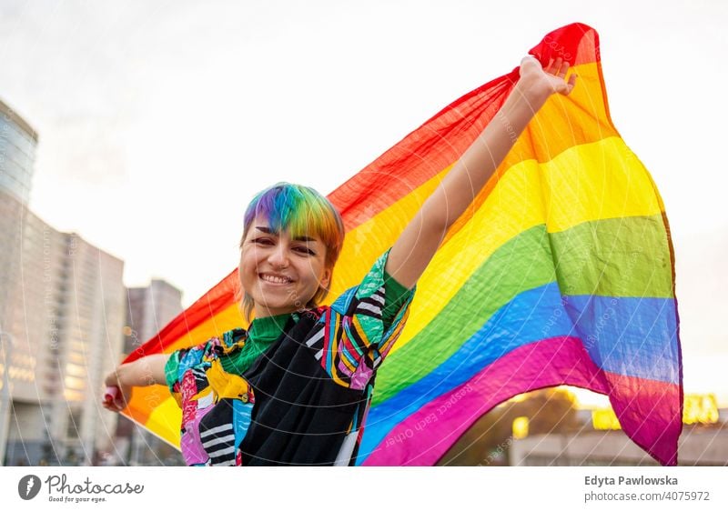 Porträt einer glücklichen nicht-binären Person, die eine Regenbogenflagge schwenkt geschlechtsfluid Gender-Fluidität lgbt Gleichstellung Homosexualität lesbisch