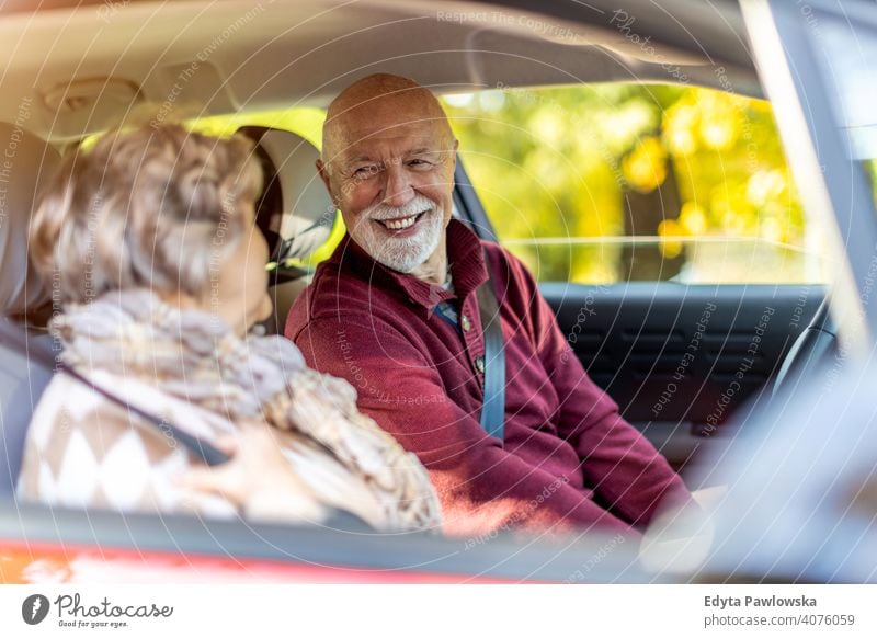 Happy Senior Couple unterwegs in ihrem Auto PKW Fahrzeug Fahrer fahren Reise reisen Ausflug Straße Verkehr Paar Liebe echte Menschen in den Ruhestand getreten