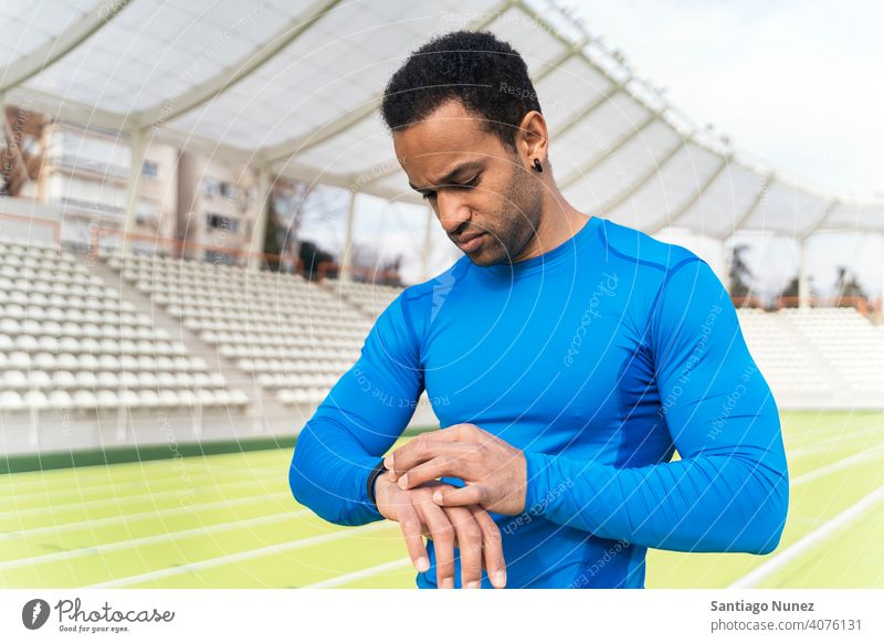 Schwarzer Sportler mit Uhr Porträt Blick Schwarzer Mann Afroamerikaner benutzend Leichtathletik eine Person zuschauen sportlich Athlet Läufer Hände herabsehend