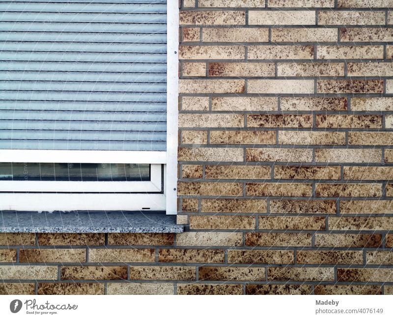 Braun gefleckter Klinkerfassade mit Fenster und heruntzergelassenem grauen Fensterladen in Bielefeld im Teutoburger Wald in Ostwestfalen-Lippe Fassade Mauerwerk
