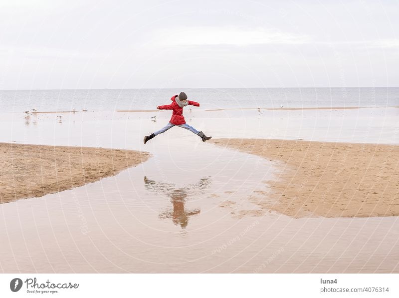 junges Mädchen springt am Stand springen Freudensprung Kind Strand Sprung Luftsprung Ostsee Freizeit Urlaub Ferien Herbst glücklich Lebensfreude fröhlich