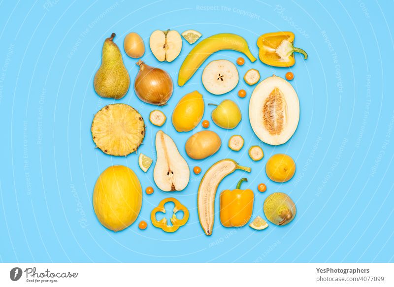 Gelbes Obst und Gemüse in der Draufsicht auf blauem Hintergrund. obere Ansicht Apfel Banane Zitrusfrüchte farbenfroh Farben Textfreiraum kreativ ausschneiden