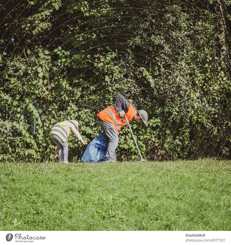 Ein Mann und ein Kind suchen am World Cleanup Day in den Büschen nach Müll clean up Weltaufräumtag Aktionstag soziales Handeln Umwelt September bürgerbewegung