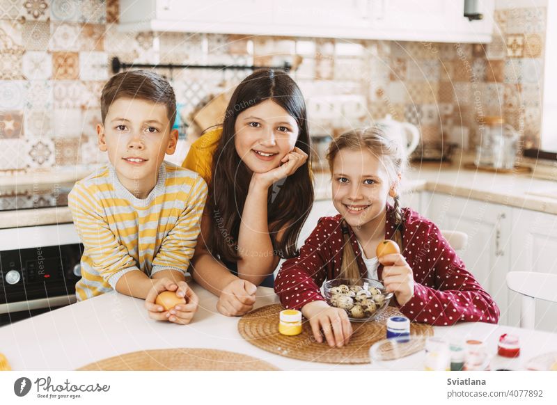 Lustige und fröhliche Kinder sitzen am Tisch malen Ostereier in verschiedenen Farben für Ostern Frühling Feiertag Vorbereitung Schwestern Bruder Ei hell Familie