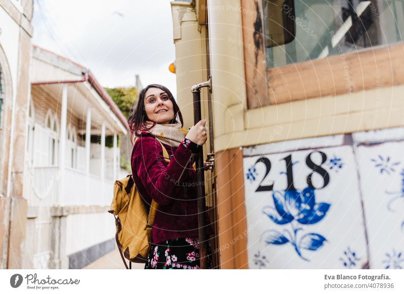 junge kaukasische Backpacker Frau Sightseeing Porto Ansichten stehen auf einem Zug. Reisen Konzept Kaukasier reisen Großstadt urban öffentlicher Verkehr gelb