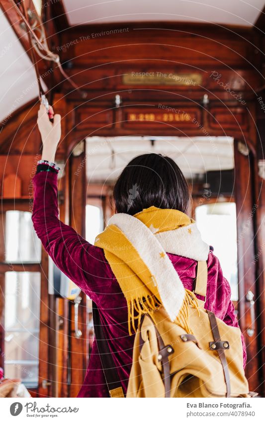 junge kaukasische Backpacker Frau Sightseeing Porto Ansichten stehen auf einem Zug. Reisen Konzept Kaukasier reisen Großstadt urban öffentlicher Verkehr gelb